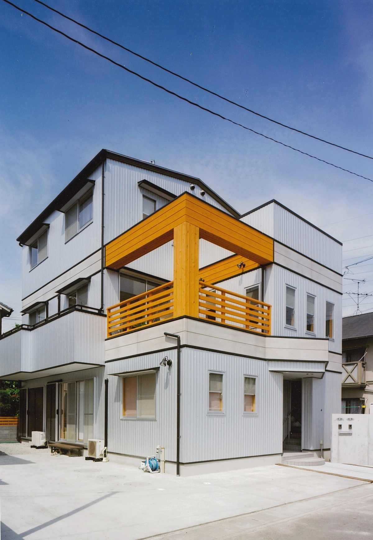 木の手すりのバルコニーがある建物の外観